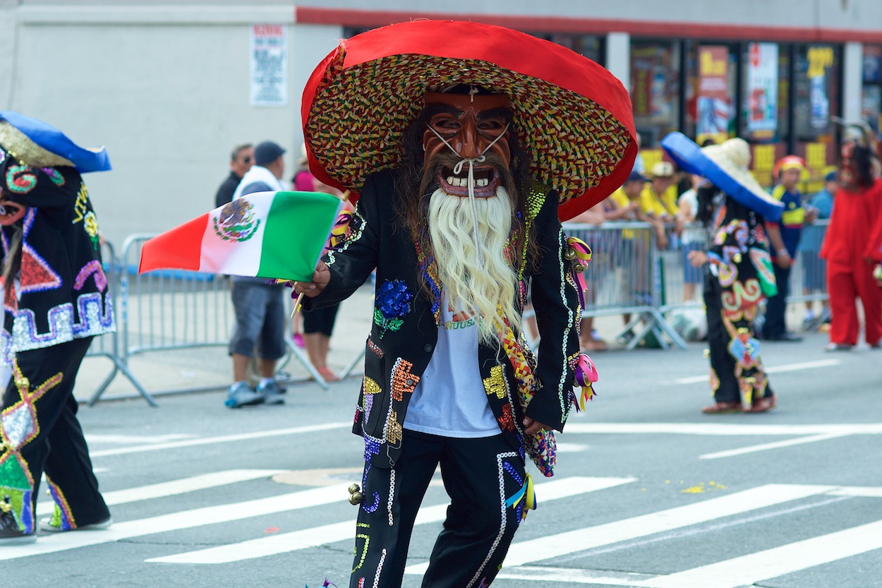 Masked Dancer along the Parade of the
                      Silleteros route in Northern Boulevard in
                      Jackson Heights, Queens for the Festival de las Flores