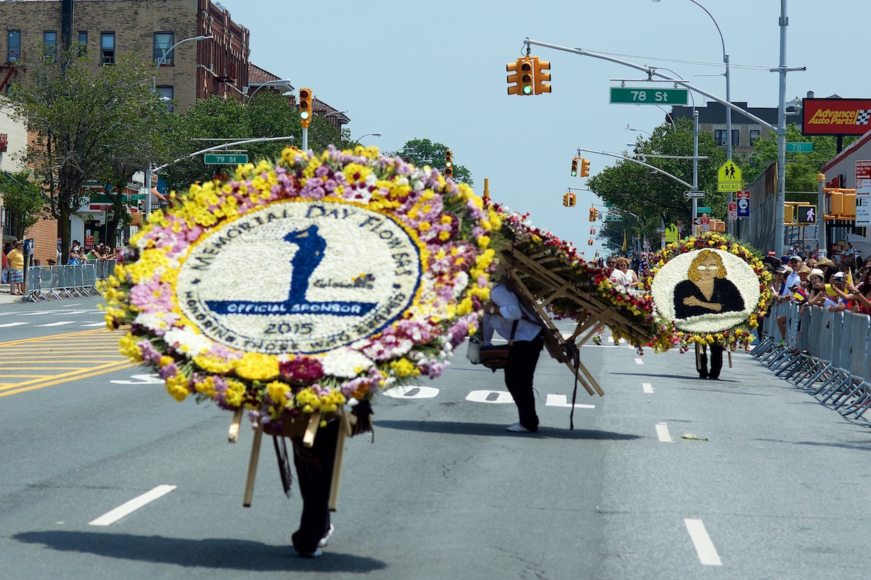 Silleteros walking down Northern Boulevard
                     in Jackson Heights, Queens for the Festival de
                     las Flores/Parade of the Silleteros