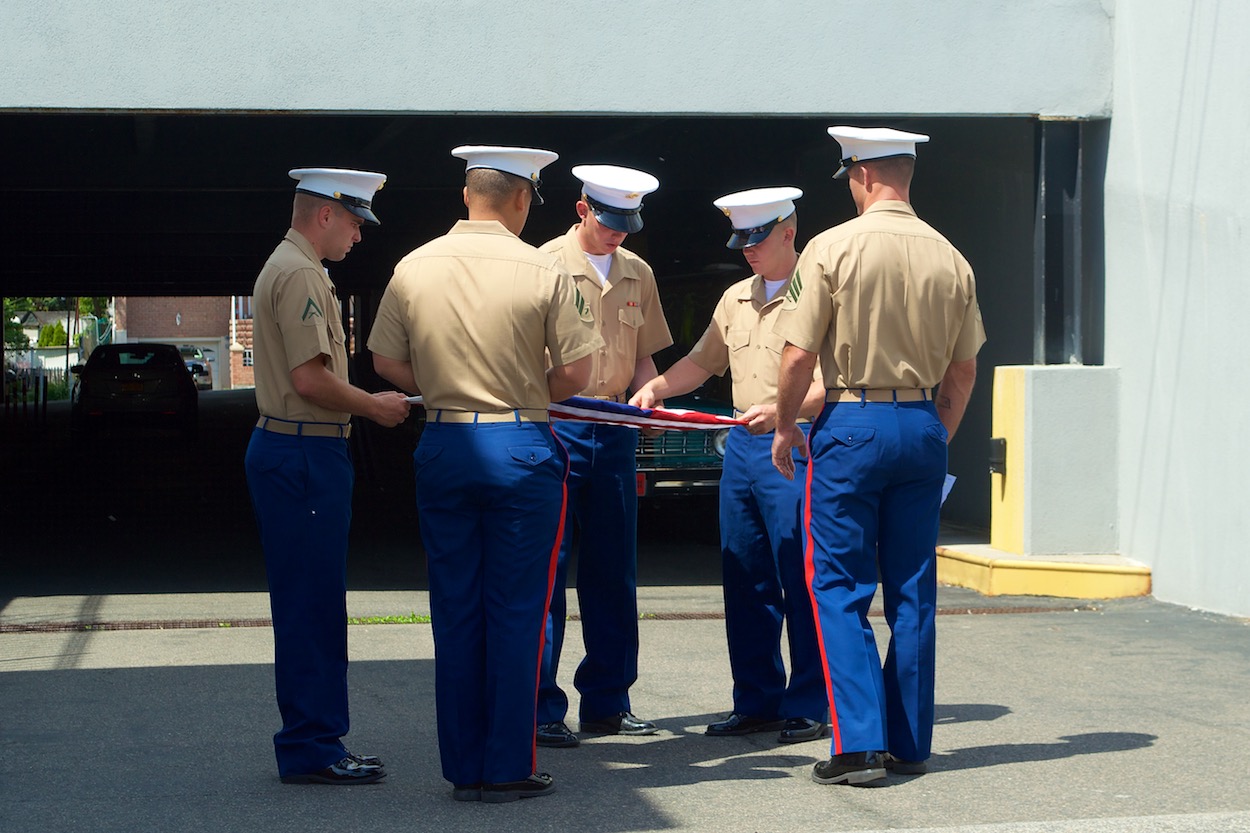 Soldiers folding the American flag after
                     the Maspeth Memorial Day parade