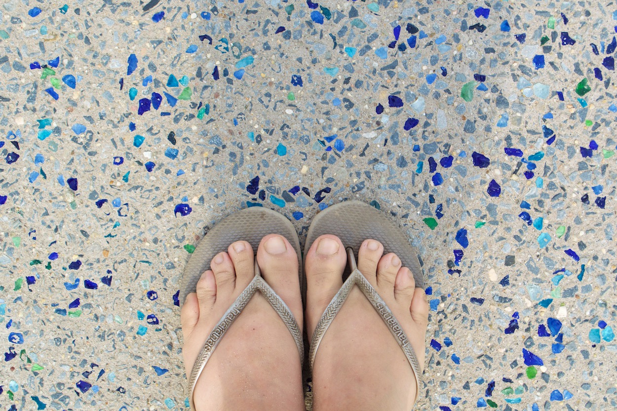 Sandy feet on the boardwalk on Rockaway Beach, Queens