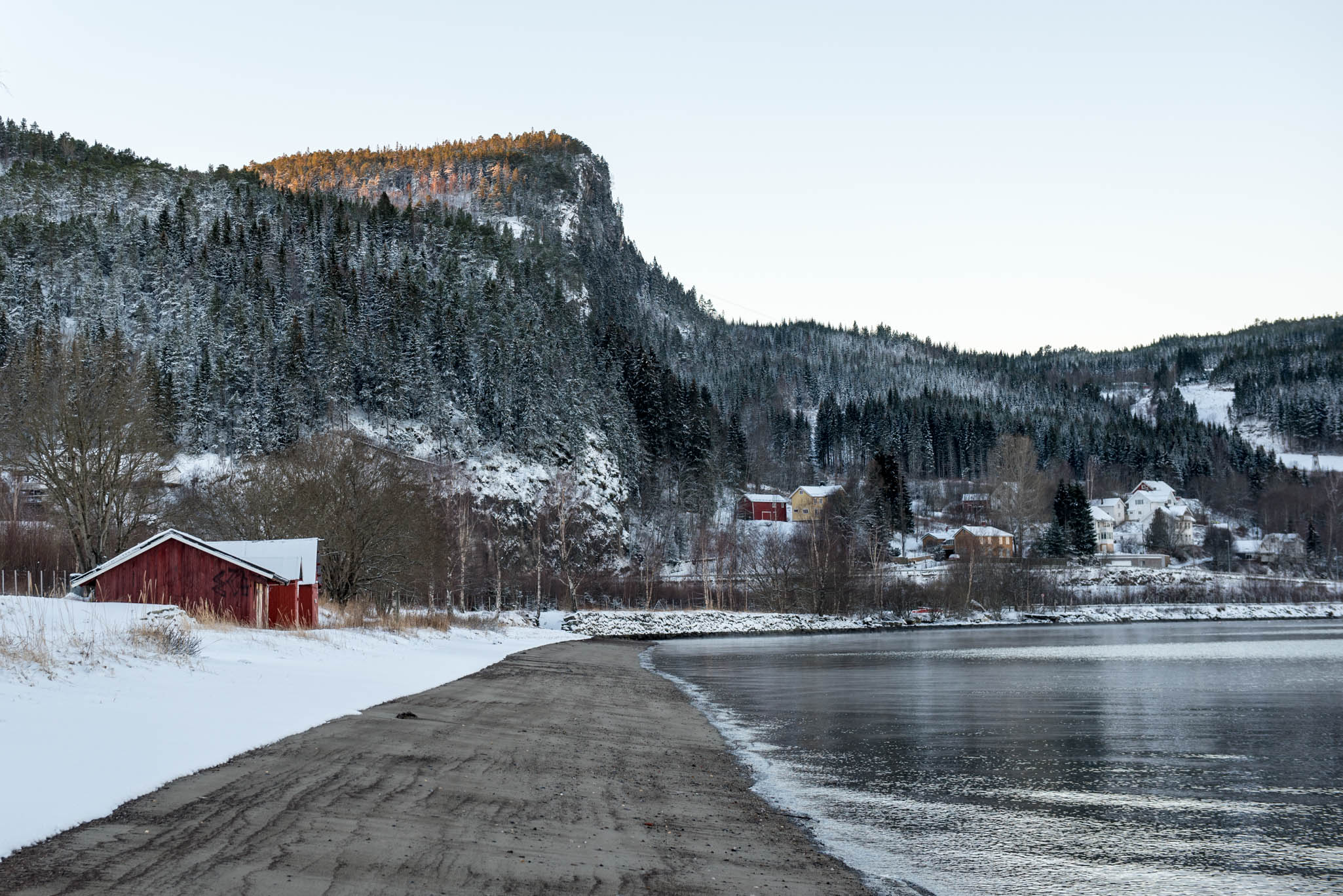 Snow and mountains over the fjord at sunrise in Hommelvik, Norway